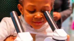 young girl experimenting with microscope