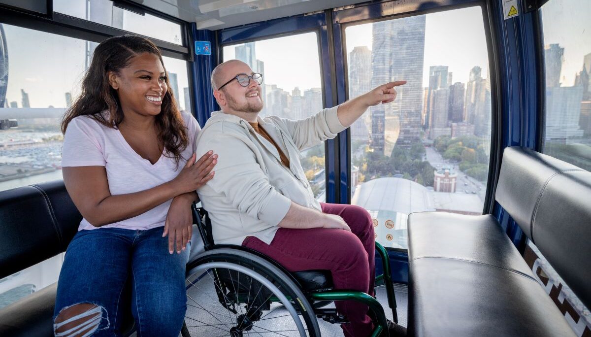 man in wheelchair accompanied by adult woman enjoying the Navy Pier Centennial Wheel
